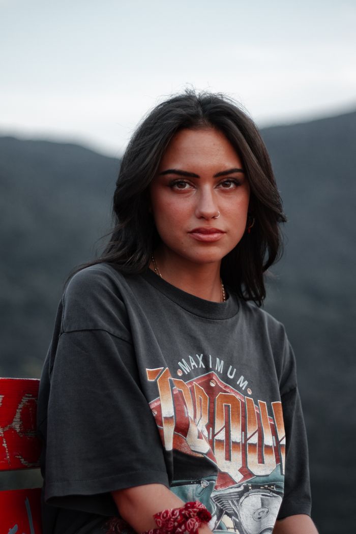 Portrait of a young woman wearing a graphic tee with a mountain view.